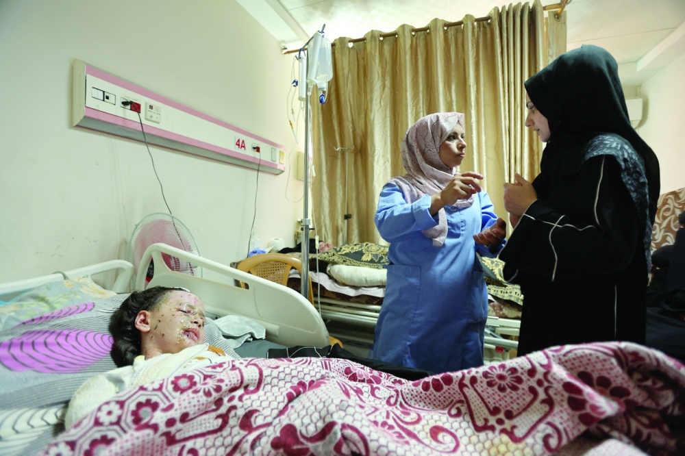 A wounded Palestinian girl, Hanan Akel, who suffered burn injuries in an Israeli strike, lies on a bed at Al Aqsa Martyrs Hospital, in Deir Al Balah, in central Gaza Strip. - Reuters

