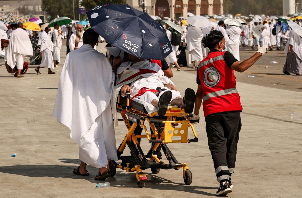  Medical team members evacuate a pilgrim, affected by the scorching heat