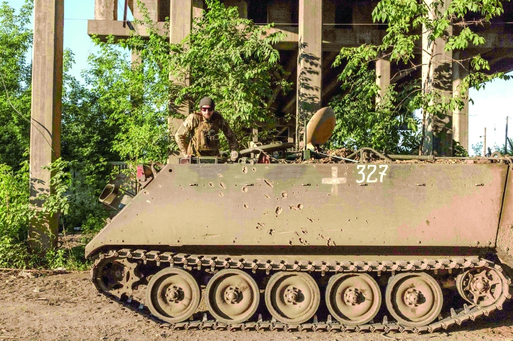 Ukrainian soldiers wait on a US-made M113 armoured personnel carrier in the Donetsk region. — AFP