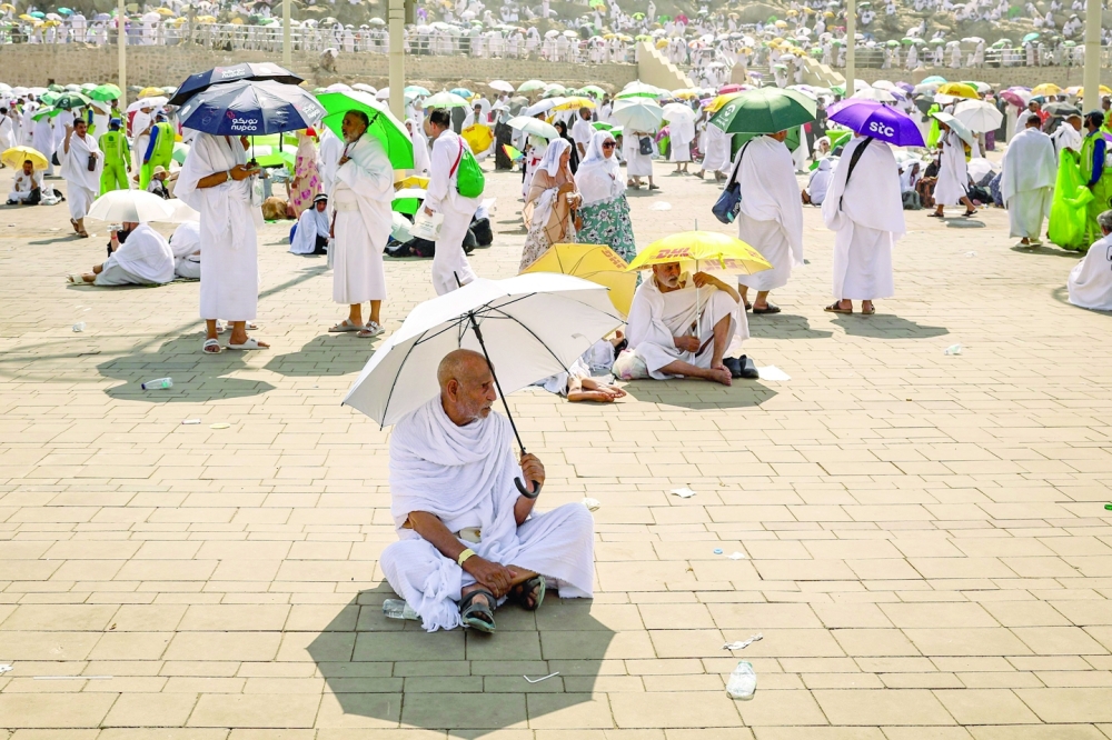 Pilgrims use umbrellas to shade themselves from the sun as they arrive at the base of Mount Arafat. — AFP file photo
