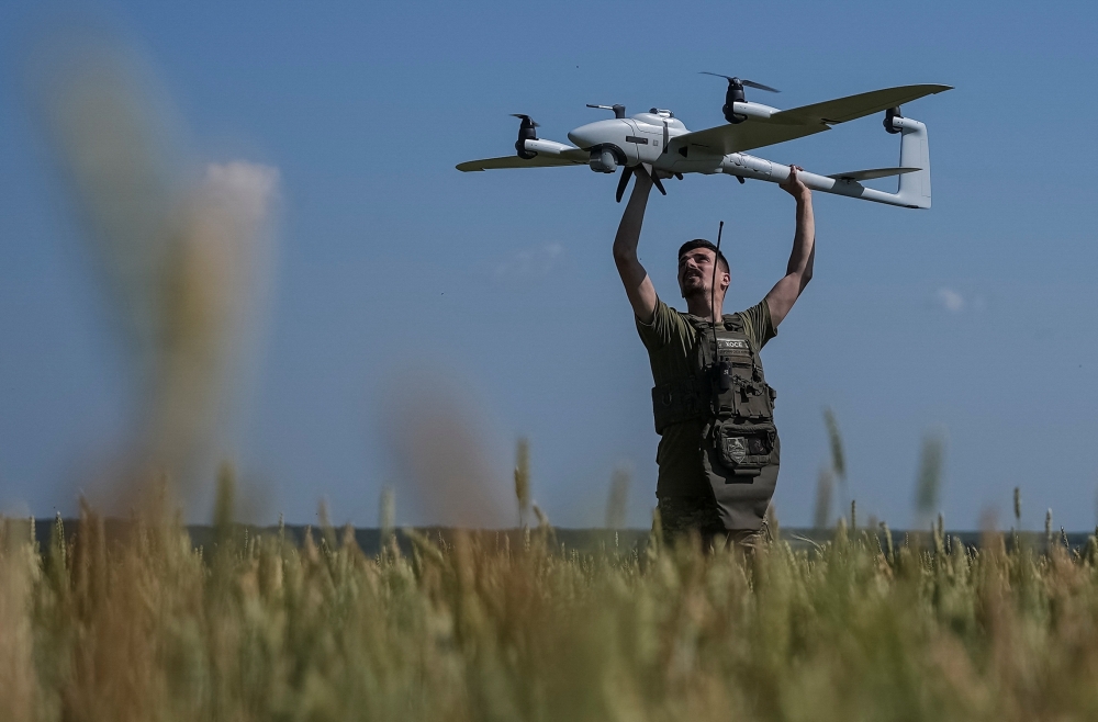 A Ukrainian serviceman, launches a mid-range reconnaissance type drone, Vector, for flying over positions of Russian troops, in a Kharkiv region