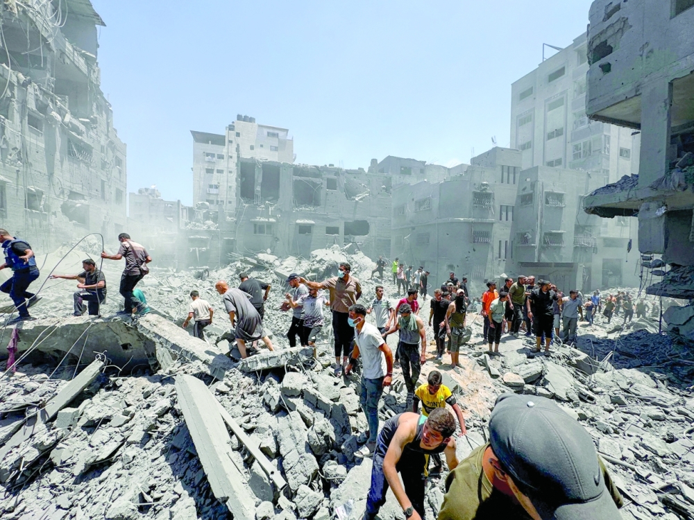 Palestinians search for casualties at the site of Israeli strikes on houses, at Al Shati refugee camp in Gaza City. — Reuters 