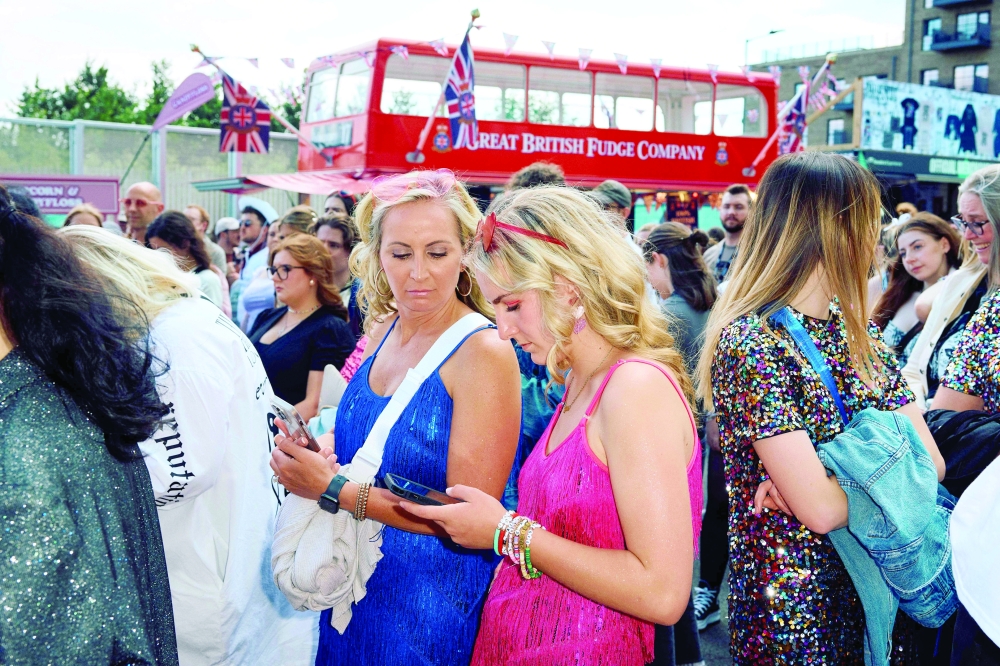 Fans queue prior to the concert of US singer and songwriter Taylor Swift as part of her 'Eras Tour' at Wembley Stadium, west of London. - AFP