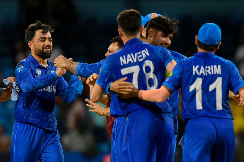 Afghanistan's captain Rashid Khan (L) celebrates his team's win of the ICC men's Twenty20 World Cup 2024 