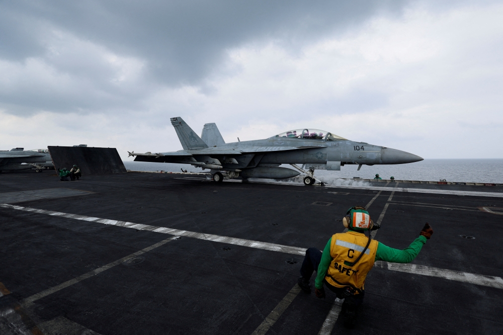 A flight operating crew member signals a F/A-18E Super Hornet fighter jet on the flight deck of the USS Dwight D. Eisenhower (CVN 69) aircraft carrier in Southern Red Sea. — Reuters file photo