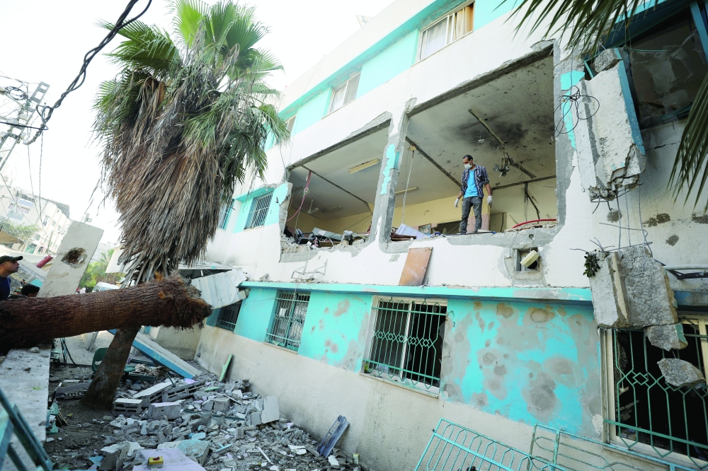 A Palestinian inspects the damages at Al-Daraj clinic which was hit in an Israeli strike, in Gaza. — Reuters 