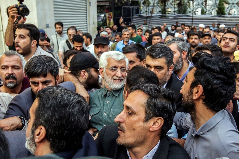 Supporters surround Iranian presidential candidate Saeed Jalili after an election campaign rally 