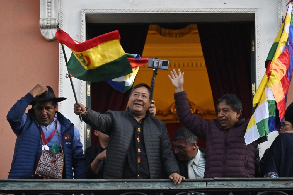 Bolivian President Luis Arce waves a Bolivian flag at the balcony of the Government Palace in La Paz. - AFP