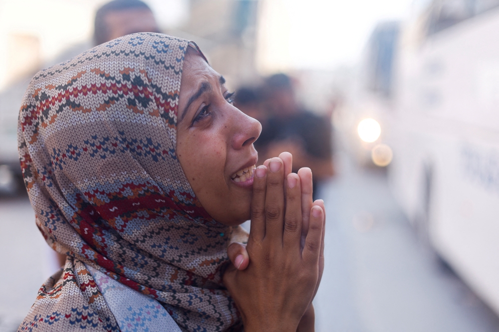 A Palestinian mother reacts as she says goodbye to her son who is a patient, before he is transferred for treatment abroad through the Kerem Shalom crossing, in Khan Younis in the southern Gaza Strip. - Reuters