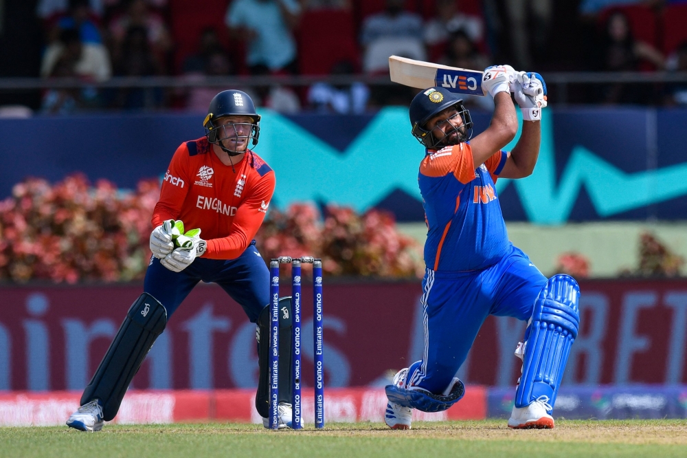 Rohit Sharma (R) of India hits 6 as Jos Buttler (L) of England looks on during the ICC men's Twenty20 World Cup 2024 semi-final cricket match 
