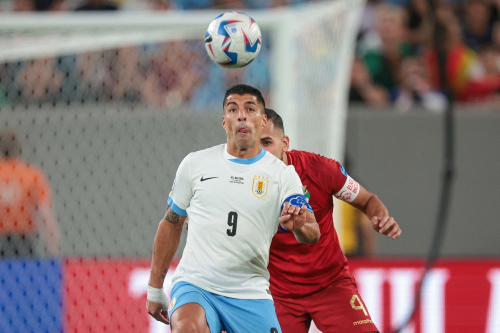 Uruguay forward Luis Suarez (9) plays the ball in front of Bolivia defender Luis Haquin (4) 