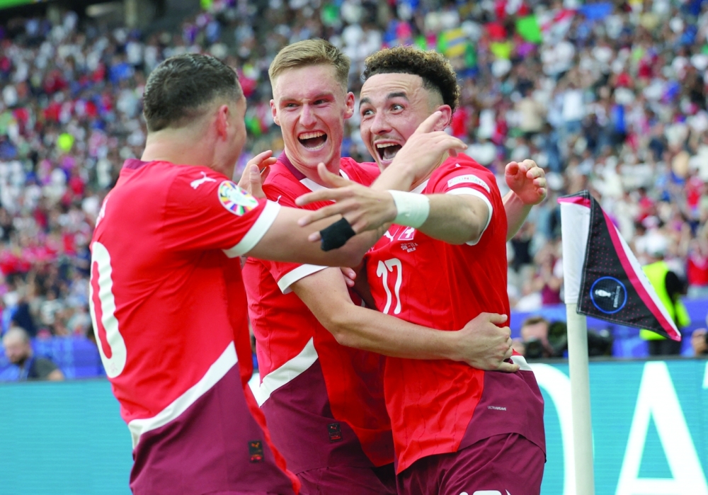 Switzerland's Ruben Vargas celebrates scoring their second goal with Michel Aebischer and Granit Xhaka. REUTERS