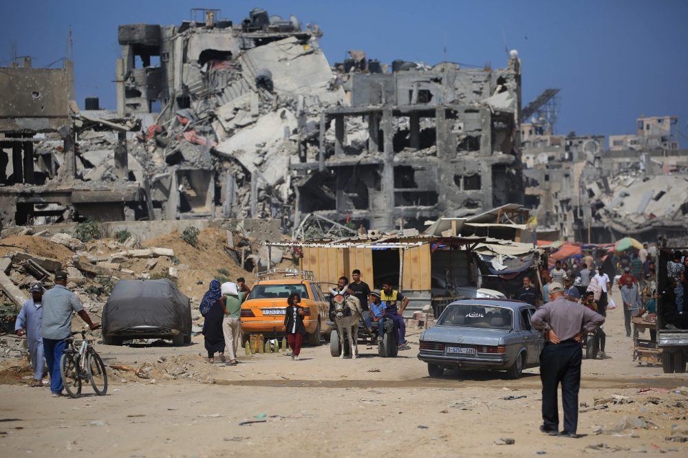 Palestinian walks down a street past destroyed buildings as some residents return to the city of Khan Yunis. — AFP 