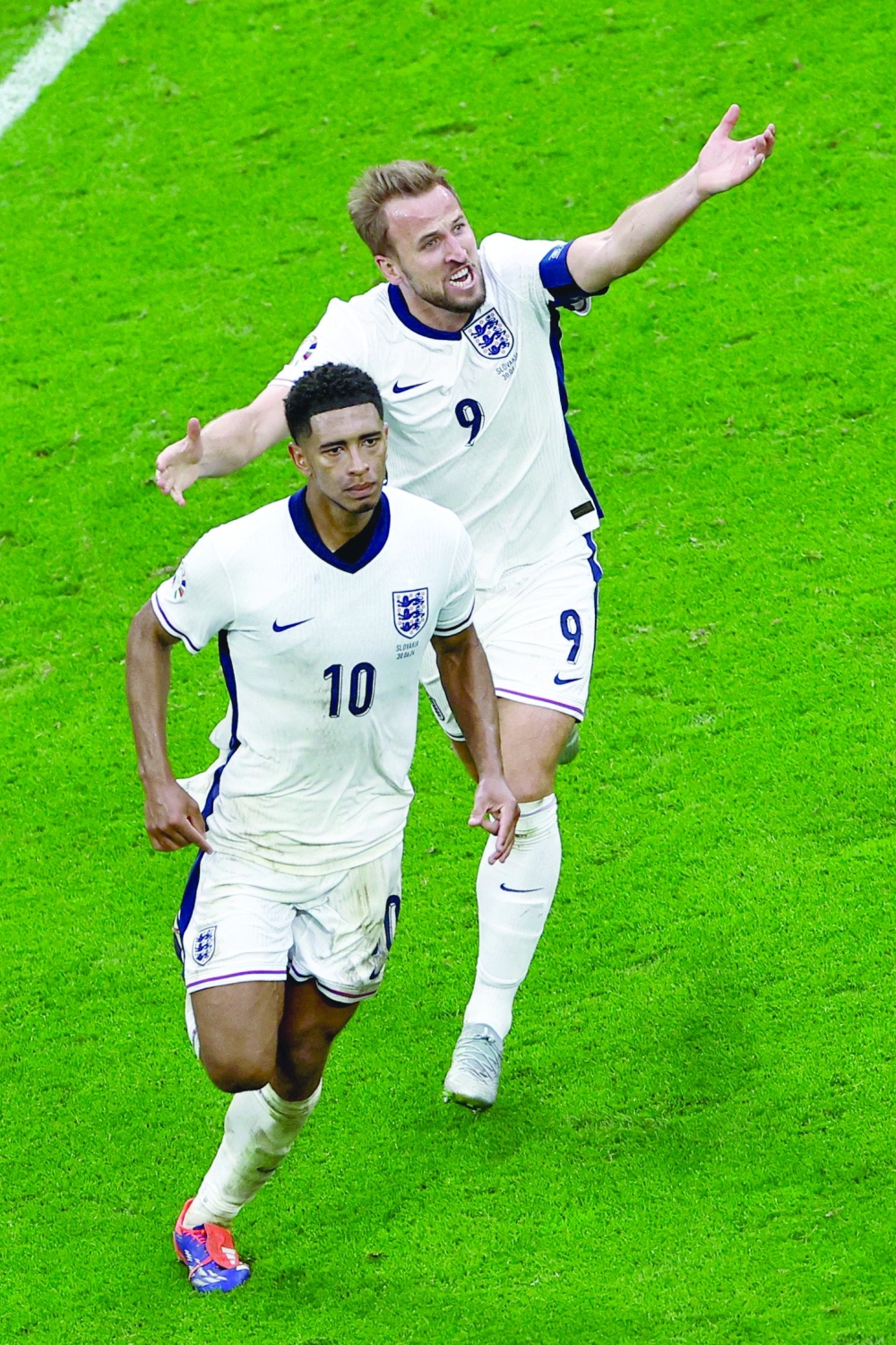 England's midfielder Jude Bellingham celebrates scoring his team's first goal with England's forward Harry Kane during the UEFA Euro 2024 round of 16 football match between England and Slovakia at the Arena AufSchalke in Gelsenkirchen on June 30, 2024.