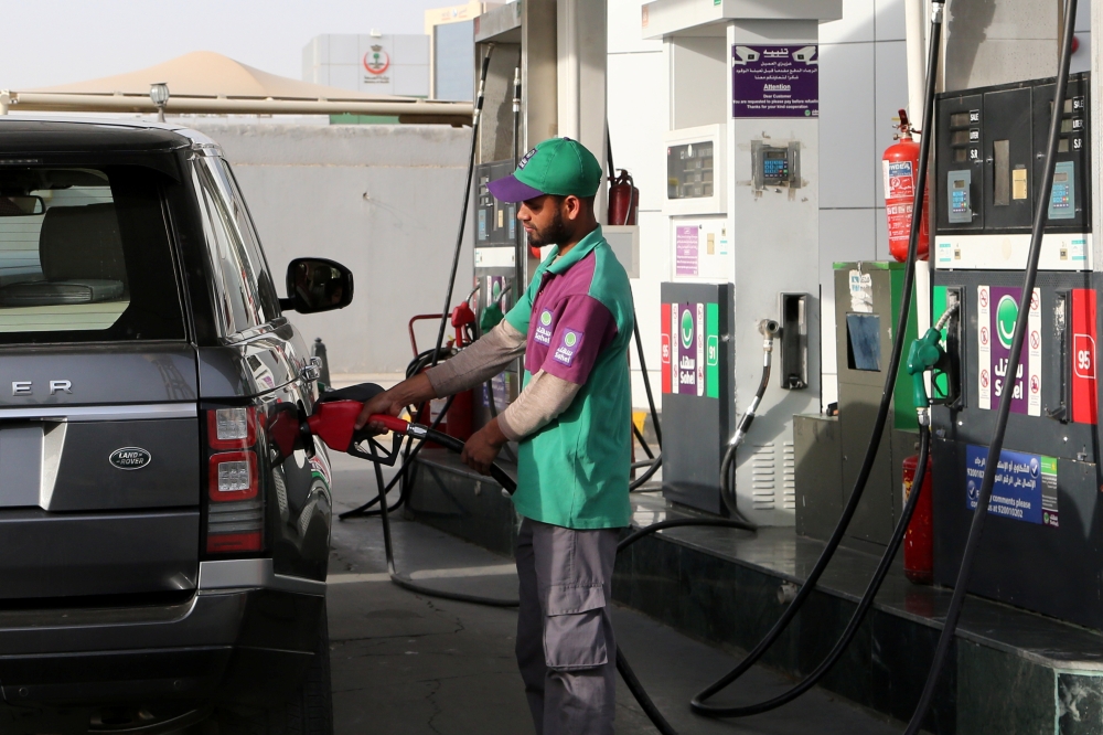 A worker fills a vehicle with petrol at a gas station in Riyadh, Saudi Arabia. — Reuters