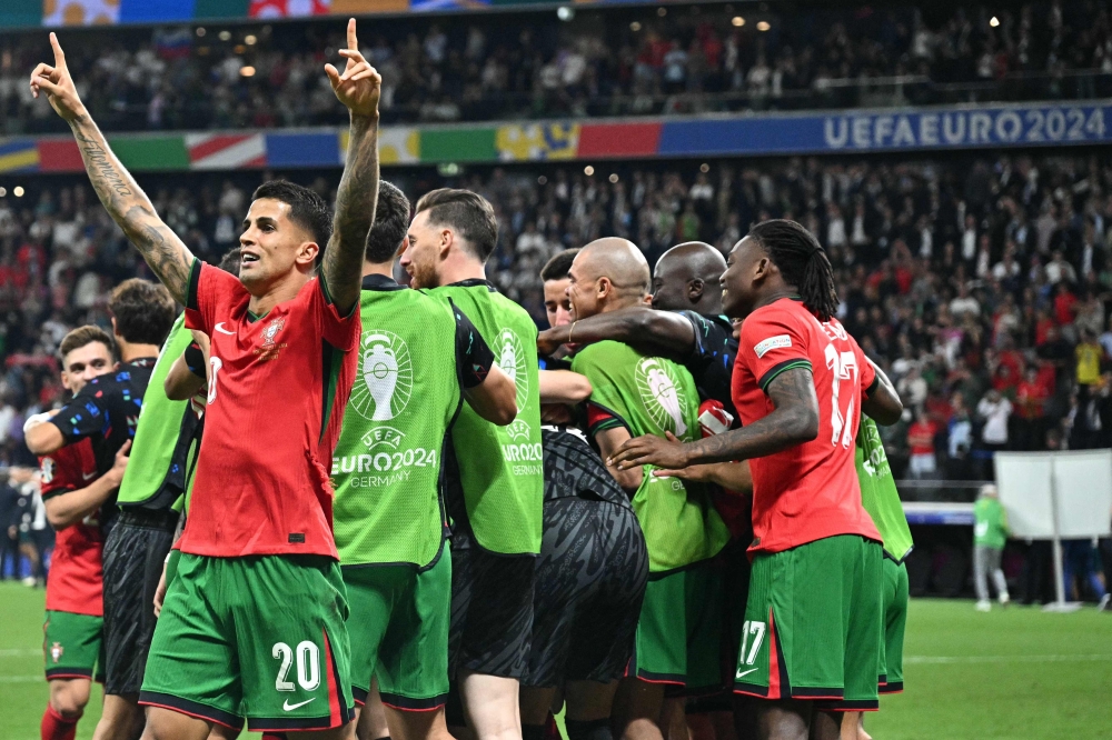 Portugal's players celebrate their win at the end of the UEFA Euro 2024 round of 16 football match. — AFP)

