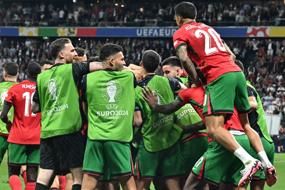 Portugal's players celebrate their win at the end of the UEFA Euro 2024 round of 16 football match. — AFP)

