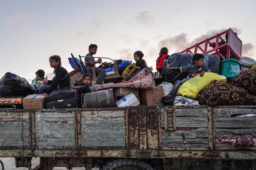 Displaced Palestinians leave an area in east Khan Yunis after the Israeli army issued a new evacuation order. — AFP