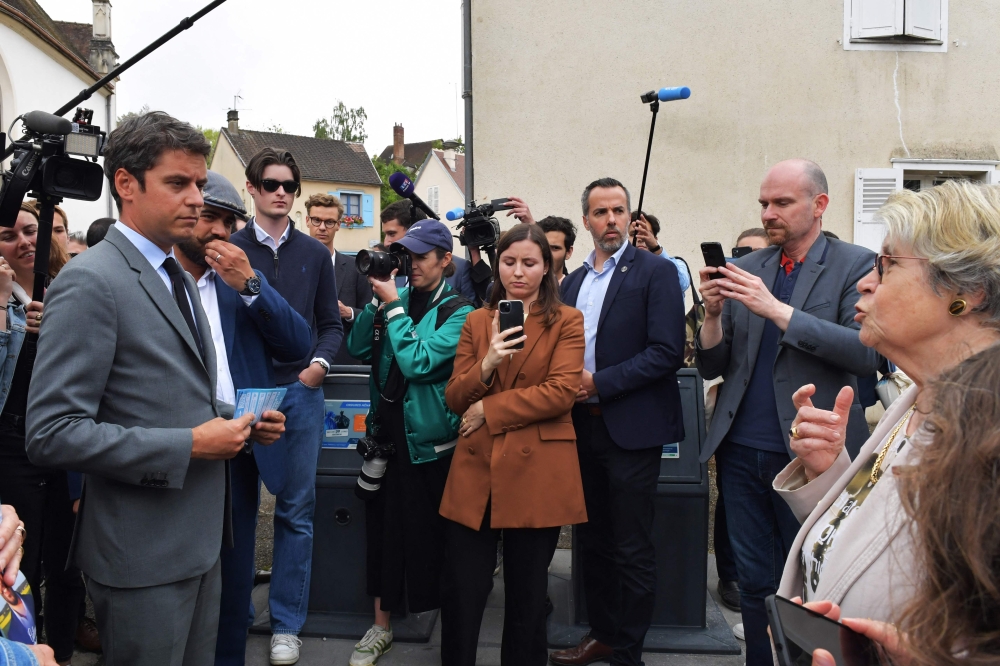 France's Prime Minister Gabriel Attal (L) speaks with a resident during a campaign visit in Chatres, centre France. — AFP 
