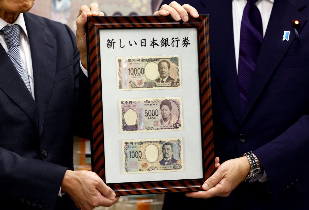 Japan's Prime Minister Fumio Kishida shows new banknotes with Bank of Japan (BOJ) Governor Kazuo Ueda, on the day of the new notes of 10,000 yen, 5,000 yen and 1,000 yen went into circulation, at the BOJ headquarters in Tokyo, Japan July 3, 2024. REUTERS/Issei Kato/Pool
