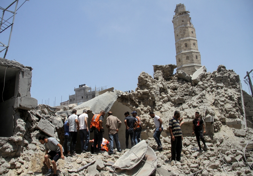 Rescuers at the site of Israeli strikes that hit a residential building and destroyed shops at Gaza's Old City market on Thursday. — Reuters