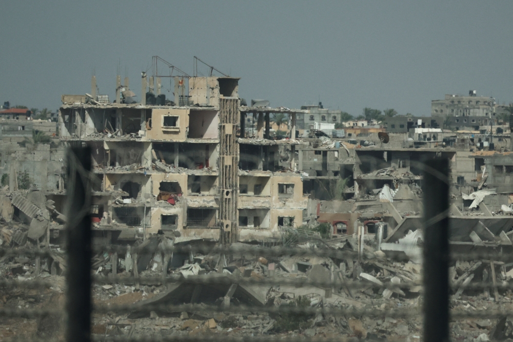 Remains of destroyed buildings in Gaza, amid the ongoing conflict between Hamas and Israel, are pictured through the Egypt-Gaza border in Rafah 