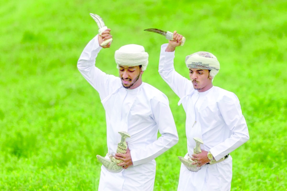 Bara’a dancers adorn themselves in traditional Dhofari attire, executing impressive jumps, with the ever-present dagger