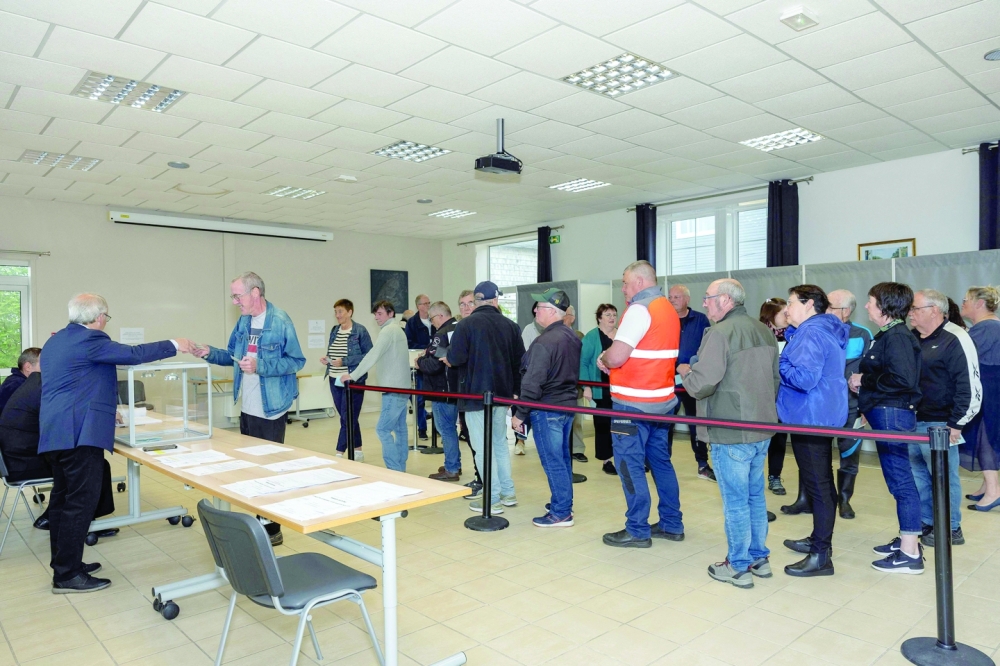 A voter casts his ballot during the second round of the French parliamentary elections, at a polling station in Saint-Pierre. — AFP