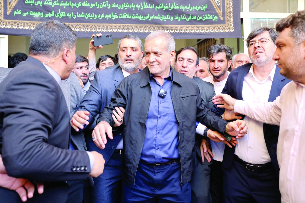 Masoud Pezeshkian (C) leaves a polling station after voting in Tehran on Friday when polls opened for Iran's runoff presidential election, pitting Pezeshkian against Saeed Jalili in the race to succeed Ebrahim Raisi, who died in a May helicopter crash. - AFP