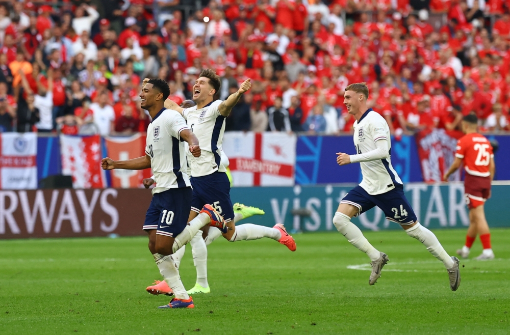 Jude Bellingham, John Stones and Cole Palmer celebrate after winning the penalty shootout.