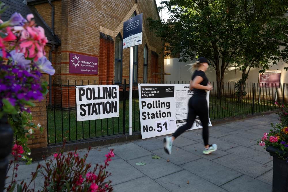 A person runs past a polling station shortly before the polls open and voting begins in the UK general election in London. — Reuters file photo