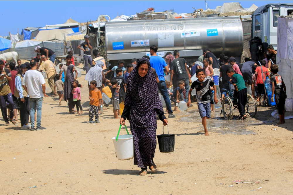Palestinians collect water from a UNICEF tanker in Deir el-Balah in the central Gaza Strip. — AFP 