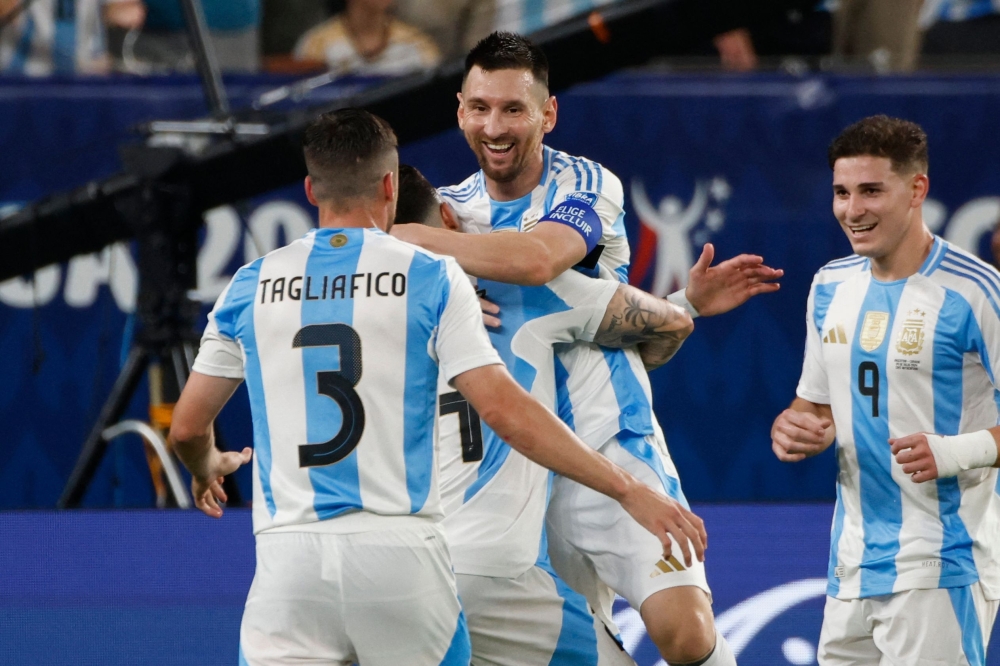 Lionel Messi celebrates with teammates after scoring second goal. — AFP

