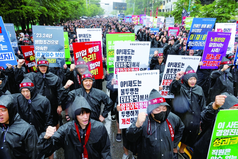 The National Samsung Electronics Union (NSEU) workers hold placards during a general strike, in Hwaseong, South Korea. — Reuters 