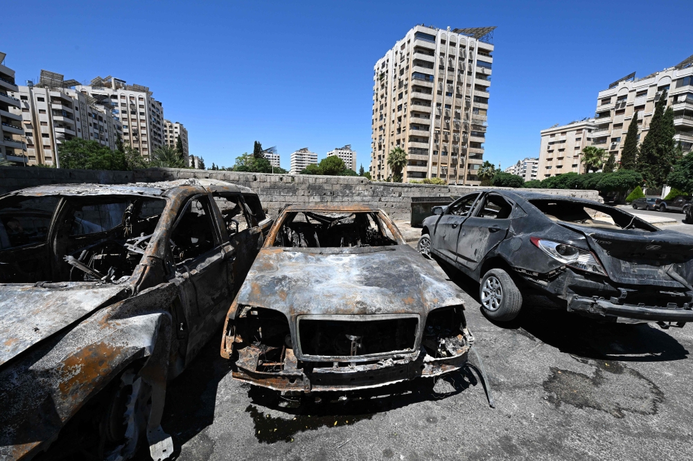 Charred cars lie in a parking lot in the aftermath of an Israeli strike in the neighbourhood of Kafr Sousse in Damascus. — AFP 