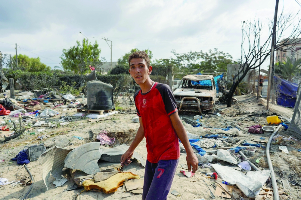 A Palestinian man walks at the site of Israeli bombardment a day earlier on the Al Mawasi displacement camp of Khan Yunis city in the southern Gaza Strip on Sunday. — AFP