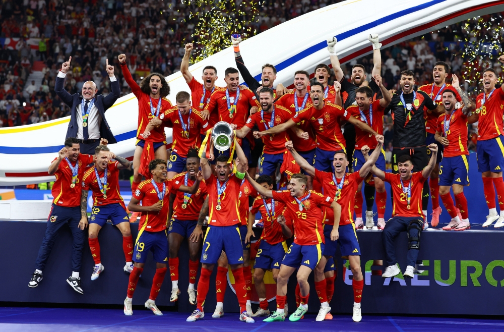 Spain's Alvaro Morata lifts the trophy as they celebrate after victory 