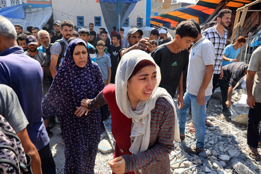 A Palestinian woman reacts after the Israeli military bombardment of the UNRWA run Abu Araban school,  in the Nuseirat refugee camp. — AFP 