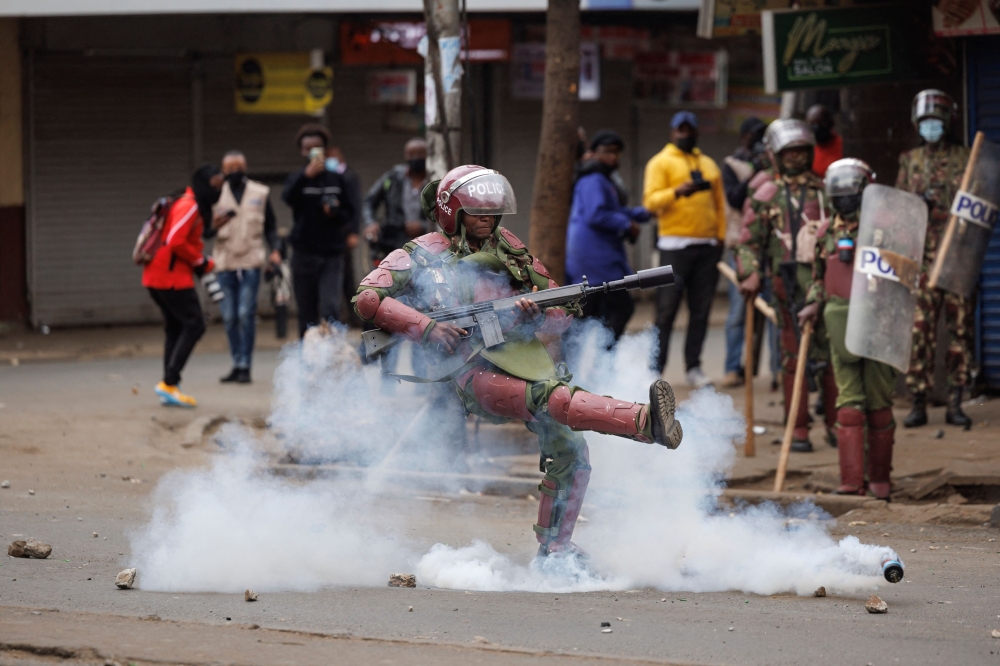 An anti-riot police officer kicks away a teargas canister during anti-government protests in Nairobi. — AFP 