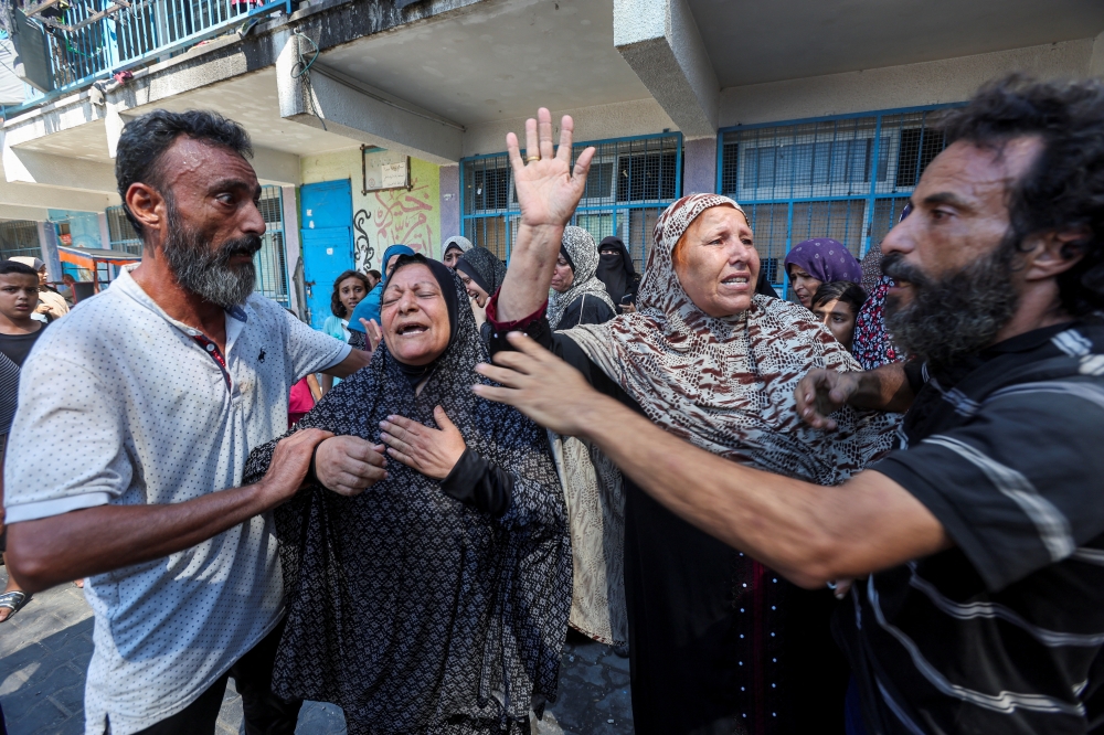 Palestinians react following an Israeli strike on a UN school sheltering displaced people, in Nuseirat. — Reuters 