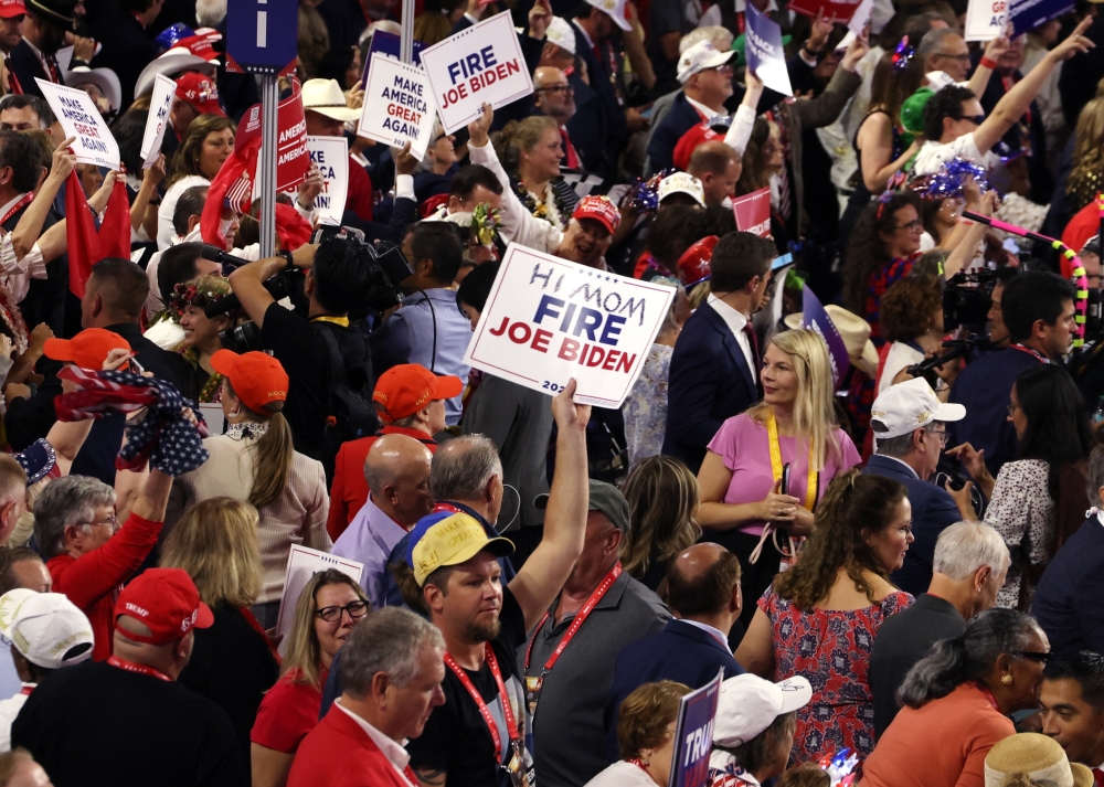 Attendees hold placards that read 'Fire Joe Biden' on Day 4 of the Republican National Convention (RNC), at the Fiserv Forum in Milwaukee, Wisconsin. - Reuters