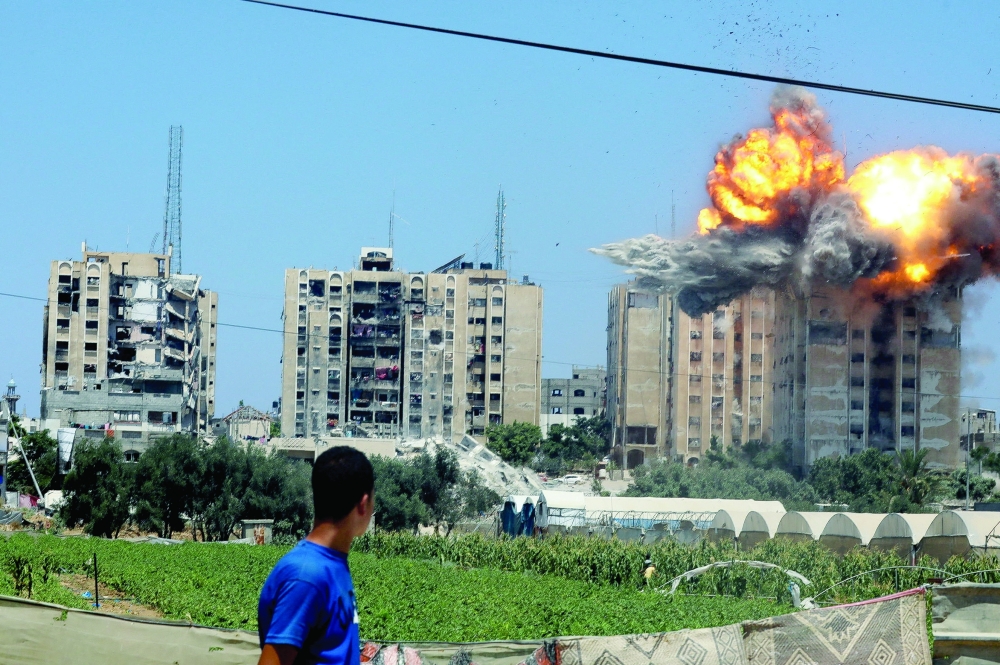 An explosion occurs following an Israeli air strike on a residential building, in Nuseirat. — Reuters 