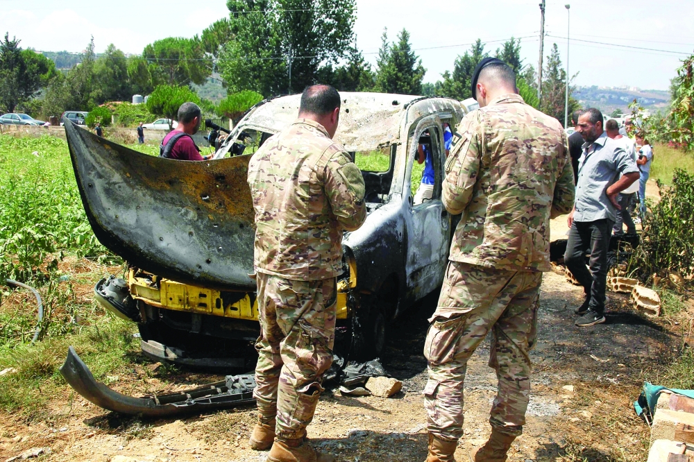 Lebanese army soldiers check the wreckage of a vehicle after an Israeli air strike near the village of Burj Al Muluk. — AFP