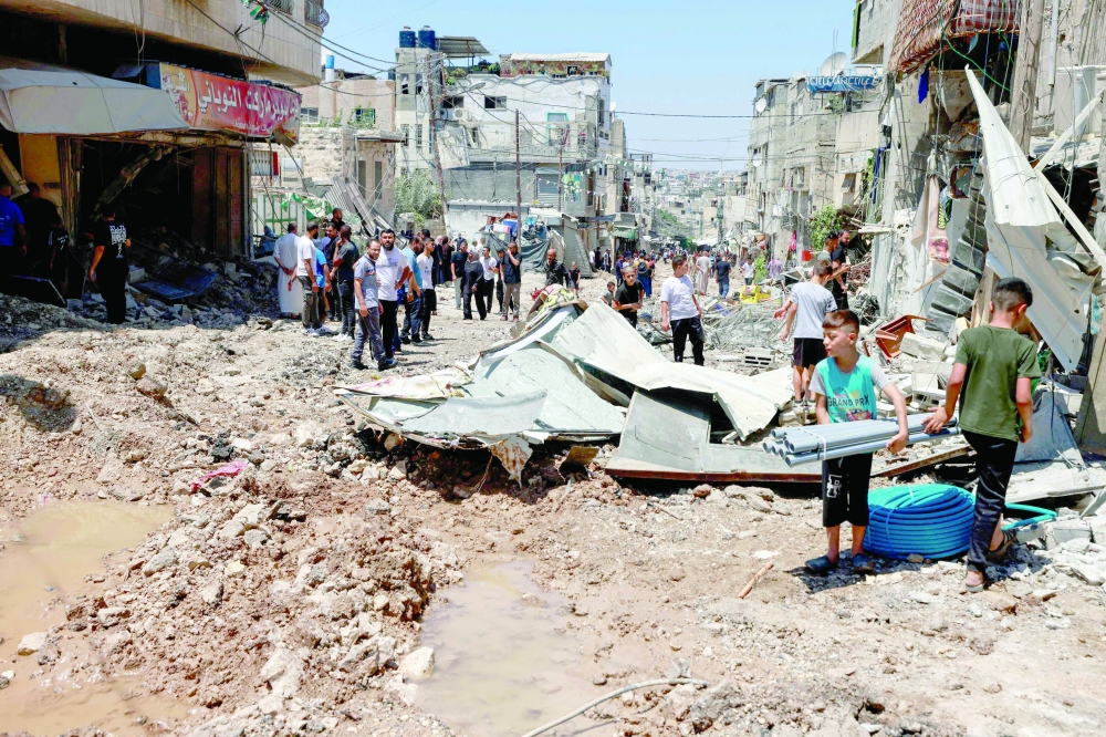 Palestinians inspect the damage following a raid by Israeli forces in the Tulkarem camp for Palestinian refugees. — AFP 