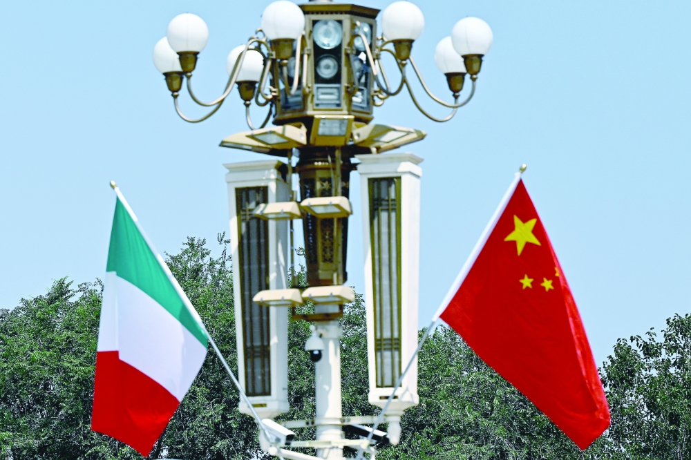 Italy's national flag flutters beside the Chinese flag outside Tiananmen Square in Beijing. - AFP

