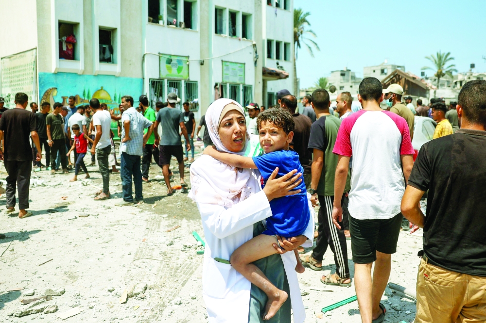 Palestinians inspect the damage following an Israeli strike on the Khadija school housing displaced people in Deir al Balah, in the central Gaza Strip amid the ongoing conflict between Israel and Hamas group. — AFP