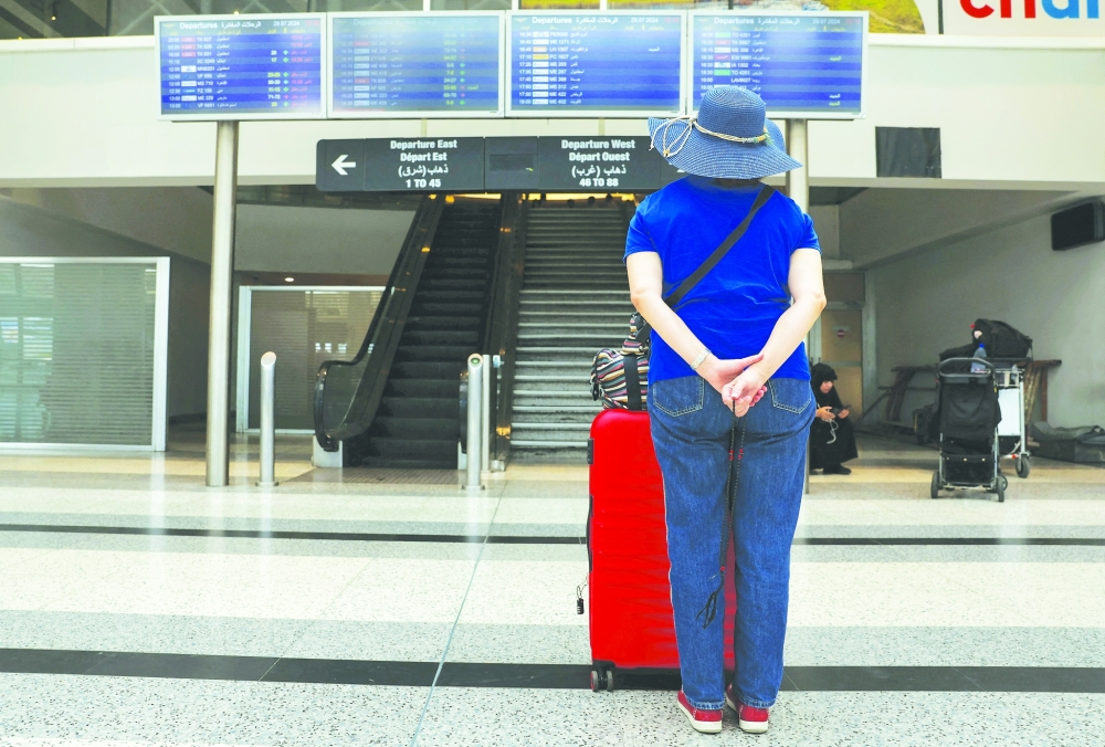 A woman checks flight information boards showing cancelled flights at the Beirut-Rafic Hariri International Airport in Beirut. — Reuters