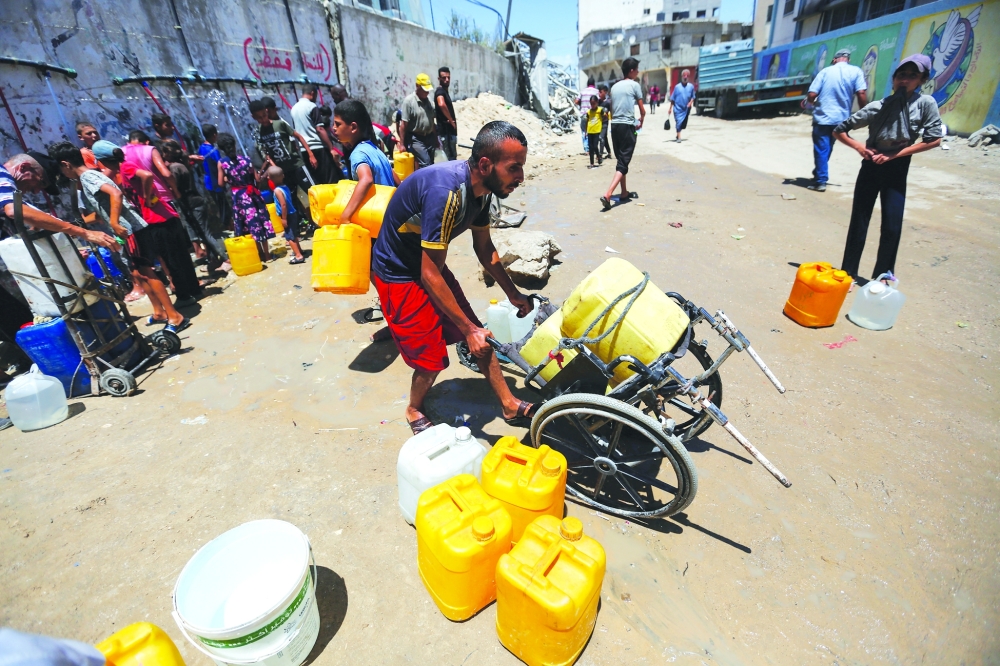 Palestinians gather to collect water amid shortages in Khan Younis in the southern Gaza Strip. — Reuters