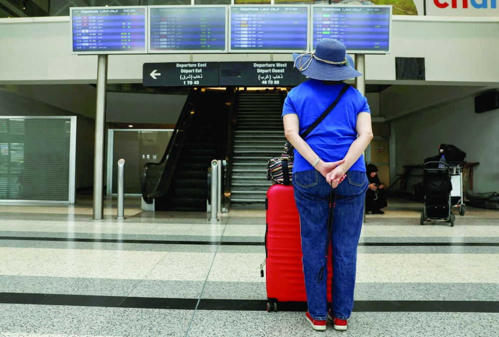 A woman checks flight information boards showing cancelled flights, at the Beirut-Rafic Hariri International Airport, in Beirut, on Monday. — Reuters