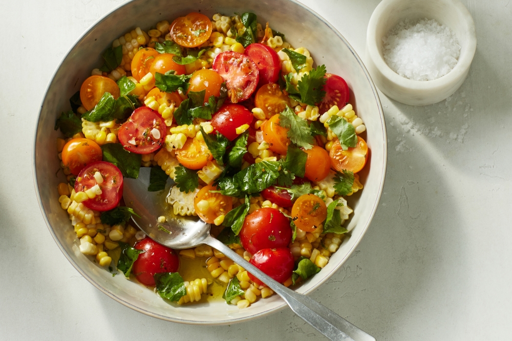 Corn salad with tomatoes, basil and cilantro. Props styled by Christina Lane. Food styled by Eugene Jho. (Bobbi Lin/The New York Times)
